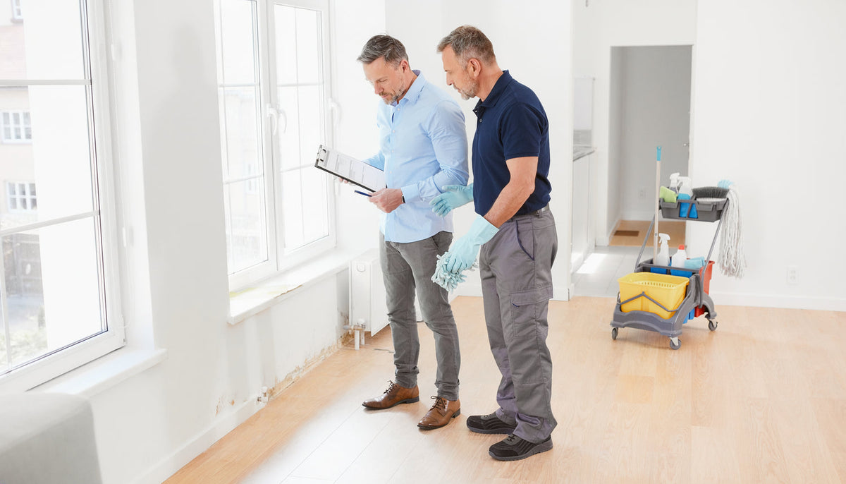 Hausverwaltung und Reinigungskraft kontrollieren eine leere Wohnung nach einem Mieterwechsel
