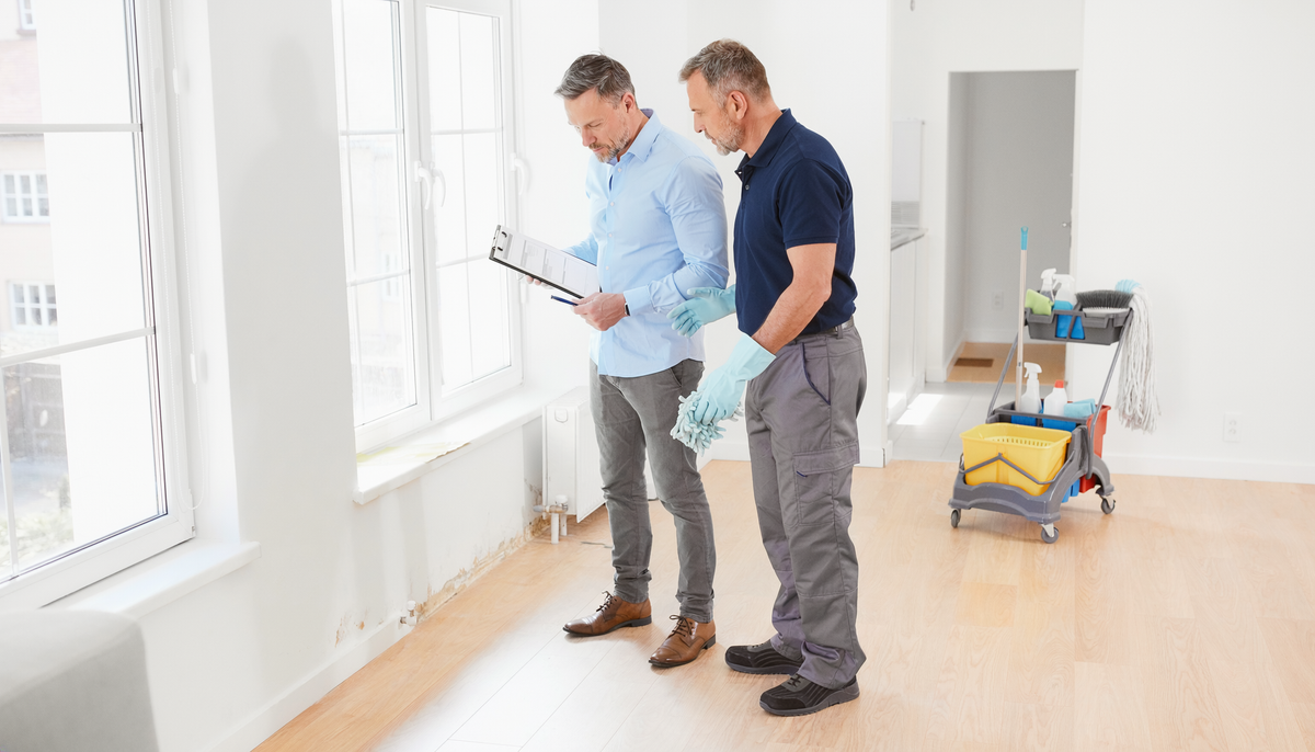 Hausverwaltung und Reinigungskraft kontrollieren eine leere Wohnung nach einem Mieterwechsel